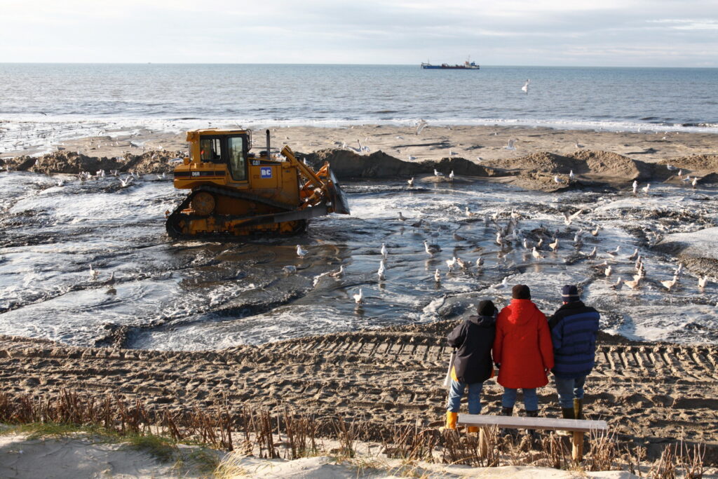 Mit schweren "Raupen" wird aufgespülter Sand am Strand verteilt // Foto © Schwarzbach / LKN.SH